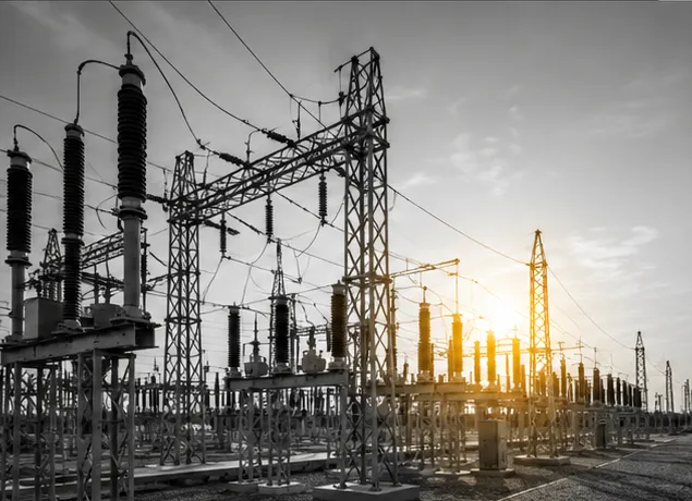Subestación eléctrica en blanco y negro con el sol al fondo